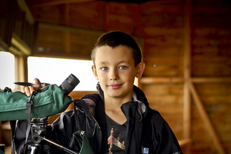 Ben in a bird hide with a telescope