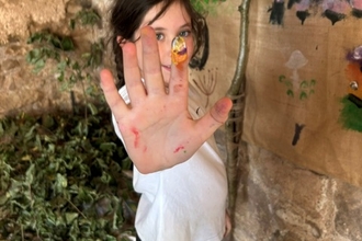 Child painting community wall mural