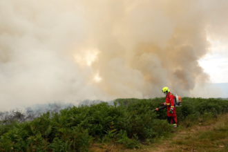 a firefighter on Blaenavon mountain with clouded smoke in the air