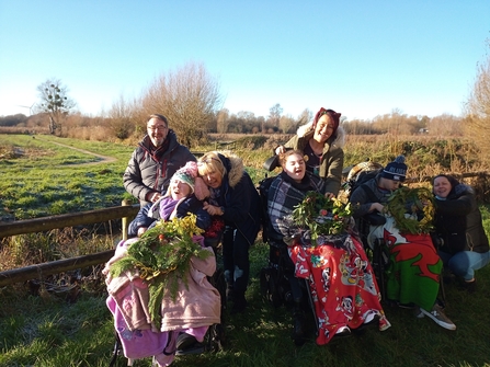 Photo of adults with complex healthcare needs with their carers after making christmas wreaths at a sunny Magor Marsh