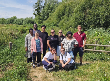 A group of 10 stood together in lush green grass at Magor Marsh