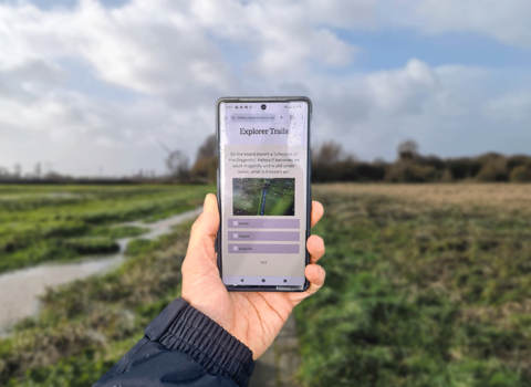 A phone screen web app with a nature reserve background